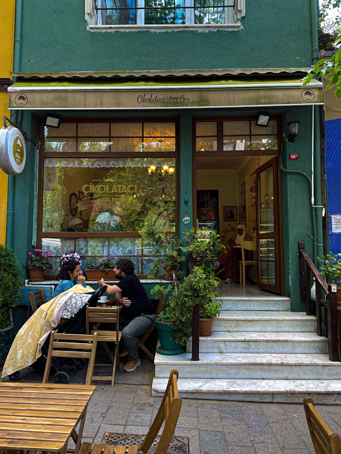 about-01 Cozy cafe with outdoor seating, plants, and lively conversation.